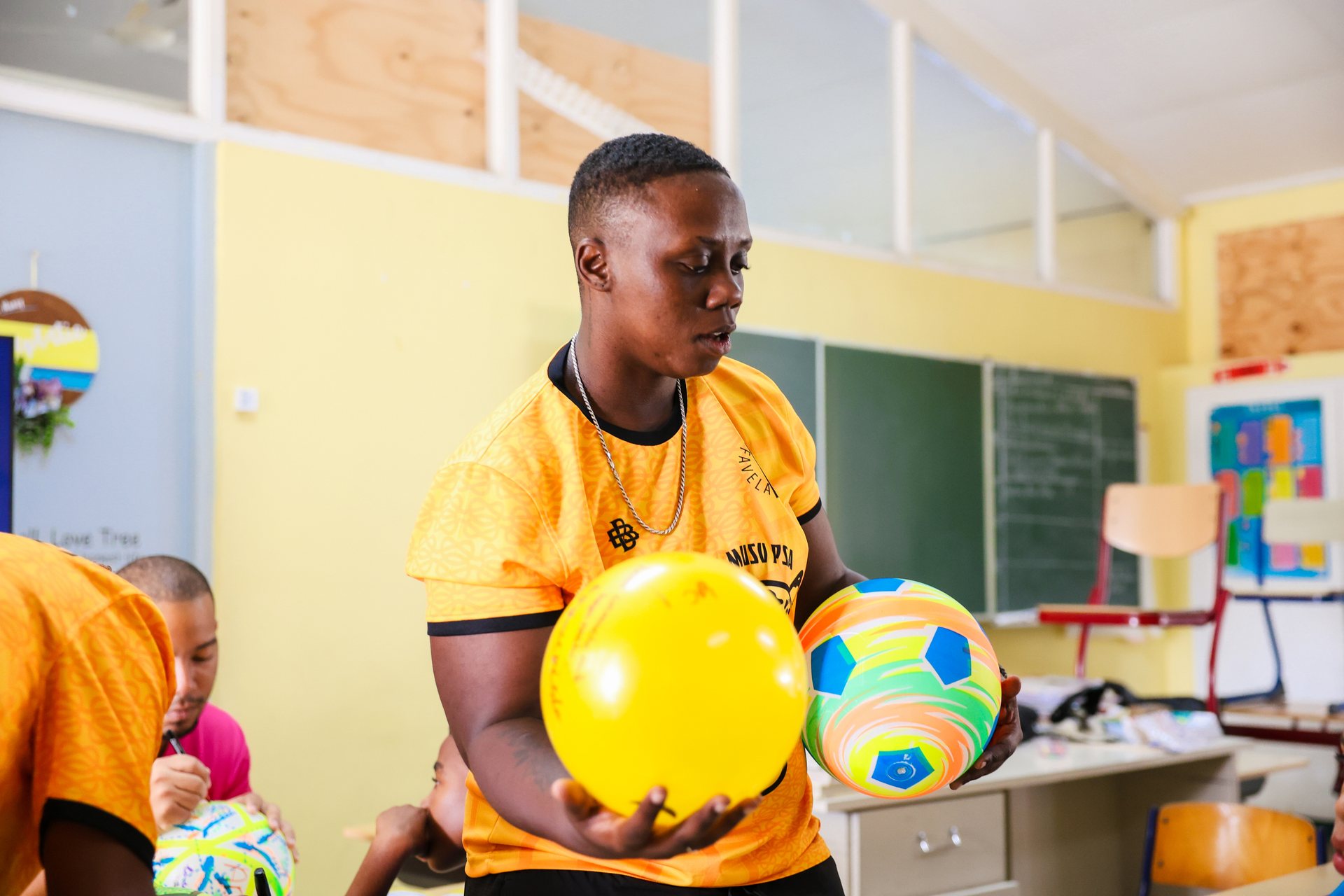 Jongen met een bal tijdens een spelactiviteit in een kleurrijk klaslokaal