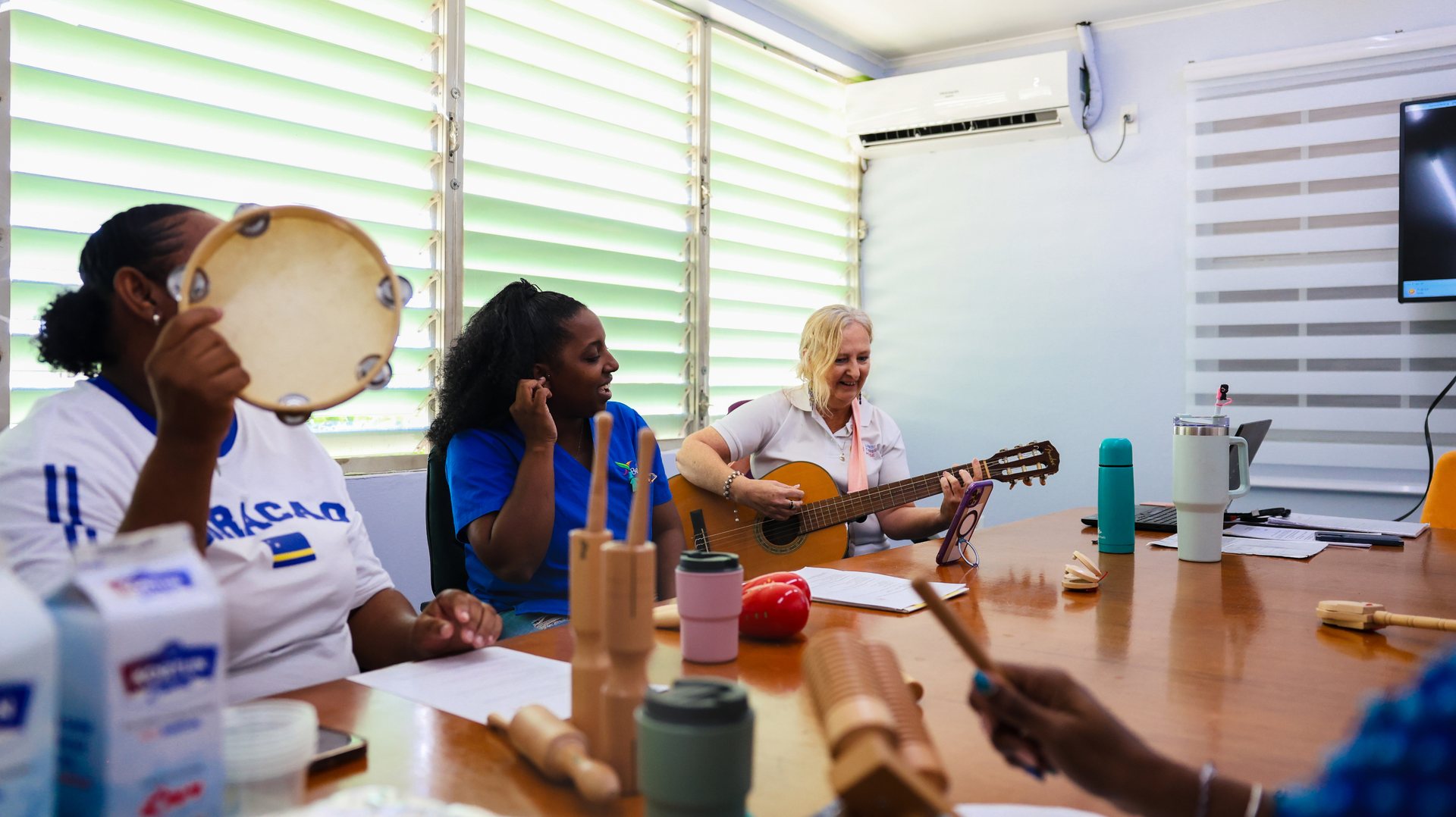 Muziekgroep met tamboerijnen en gitaar tijdens een activiteit voor ouderen